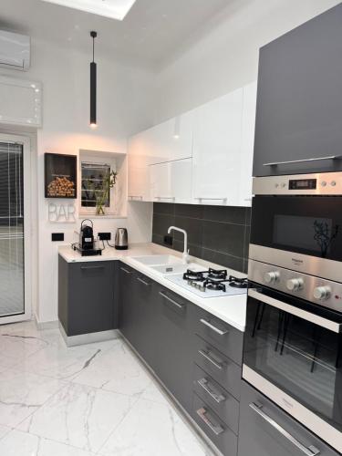 a kitchen with white counters and a stove top oven at RaRoom Supernova H in Torre del Greco