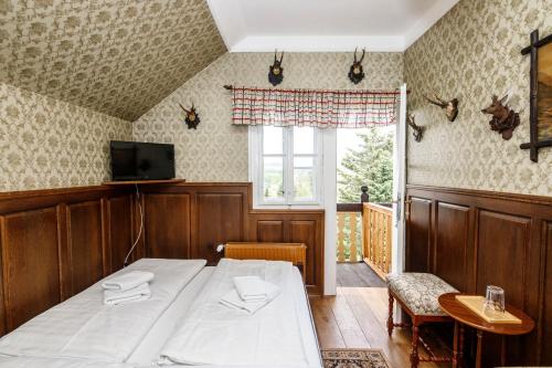 Schlafzimmer mit einem Bett, einem TV und einem Fenster in der Unterkunft Penzion Letohrádek in Frýdlant nad Ostravicí