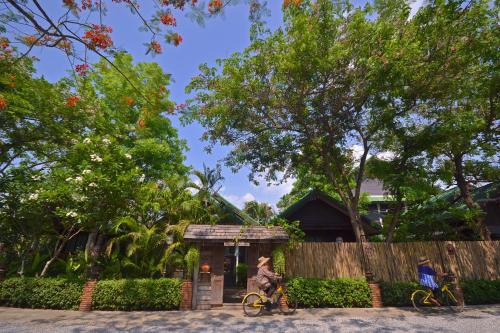 a person riding a bike in front of a fence at Thai Thai Sukhothai Resort in Sukhothai