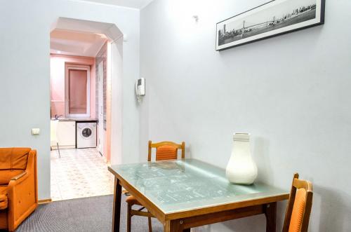 a dining room table with a vase on the wall at Naykova district Apartments in Kharkiv