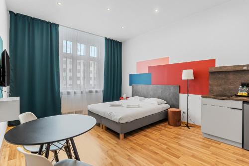 1 dormitorio con 1 cama, mesa y sillas en Apartamenty Centrum Dworzec PKP self check-in 24h, en Katowice