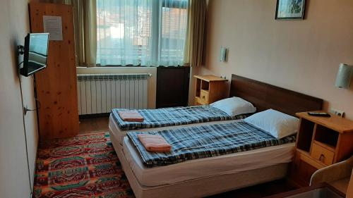 a hotel room with two beds and a window at Guest House Garbevi in Dobrinishte
