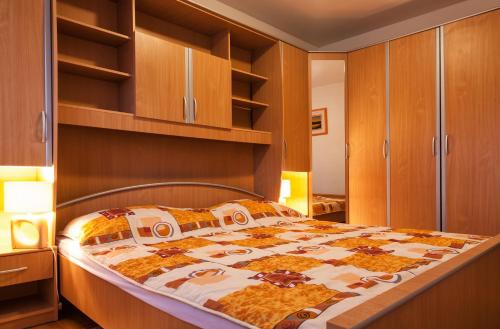 1 dormitorio con 1 cama y armarios de madera en Apartment Aldo, en Pula
