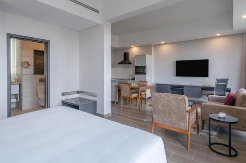a hotel room with a bed and a living room at Dusit Princess Hotel Residences Nairobi in Nairobi