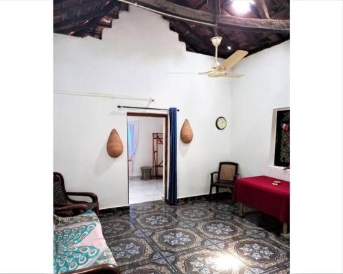 ein Wohnzimmer mit einem Sofa und einem roten Tisch in der Unterkunft Cockerel Homestay - Traditional Beach Village - Goa in Canacona