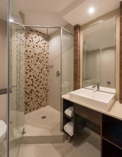 a bathroom with a sink and a shower at Park Inn by Radisson, Lagos Victoria Island in Lagos