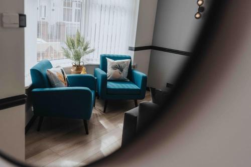 een kamer met 2 stoelen, een tafel en een raam bij Orange Rentals- 3 bed Scouse House Sleeps up to 8 guests in Liverpool