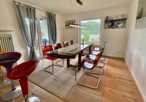 una sala da pranzo con tavolo e sedie rosse di Ferienwohnung Strandbad - Alpen PopArt am See a Schliersee