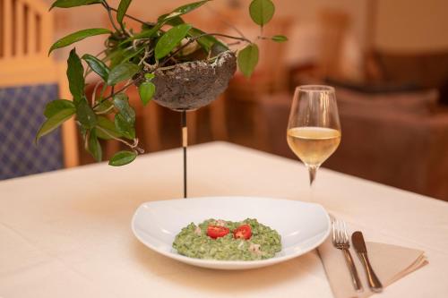 a plate of food on a table with a glass of wine at Hotel Rierhof in Chiusa