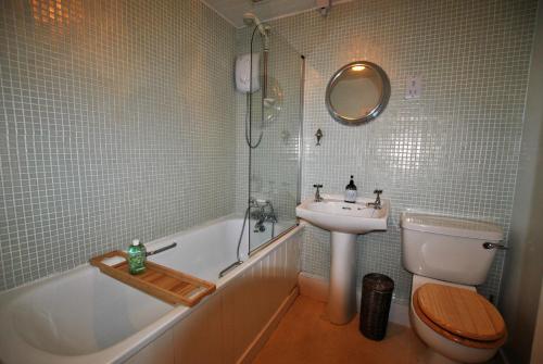 a bathroom with a sink and a tub and a toilet at Heron Cottage- fishermans cottage by the sea in Anstruther