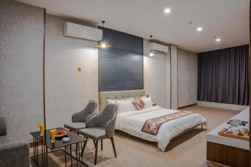 a hotel room with a bed and a table and chairs at Bloom Hotel in Baghdad