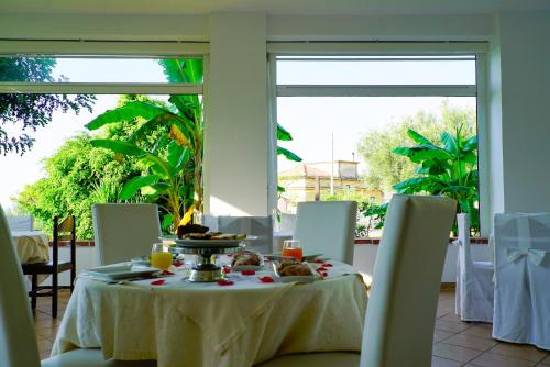 a table with a plate of food on it in front of windows at Hotel America in Marina di Camerota