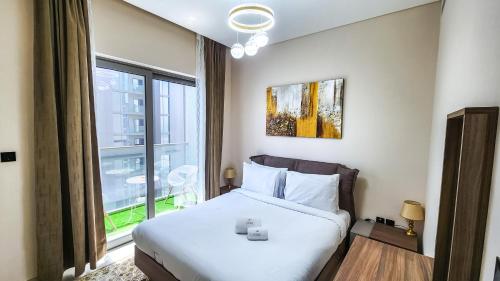 ein Schlafzimmer mit einem Bett und einem großen Fenster in der Unterkunft STAY BY LATINEM Luxury 1BR Holiday Home CVR B2601 near Burj Khalifa in Dubai