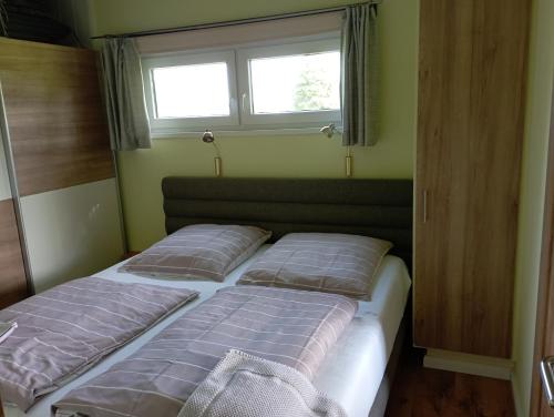 two beds in a small room with a window at Ferienhaus "Op'n Barg" in Holzbunge