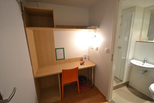 a small bathroom with a desk and a sink at Fasthotel Tours Sud in Chambray-lès-Tours