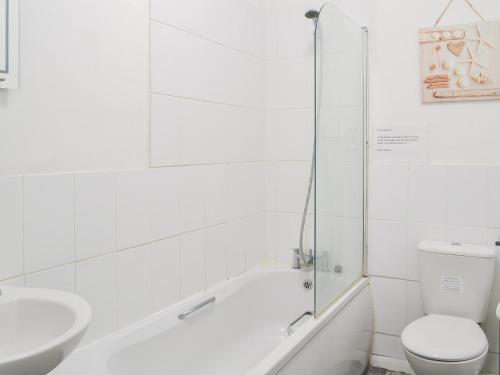a bathroom with a tub and a toilet and a sink at Harbour View - Uk44164 in Bridlington