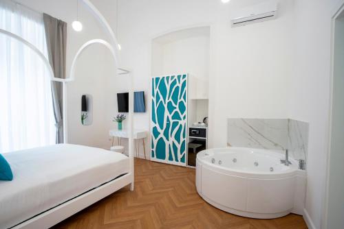 a white bedroom with a bed and a bath tub at Relais al Castello in Castellammare di Stabia