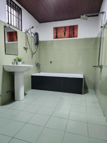 ein Badezimmer mit einer Badewanne und einem Waschbecken in der Unterkunft Nature Springs Belihul oya in Balangoda