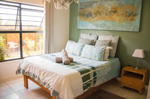a bed with a stuffed animal on it in a bedroom at 150 The Blyde Crystal Clear Lagoon 3 Bedroom Garden Apartment in Pretoria