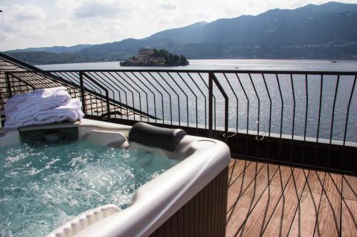 a hot tub on a balcony with a view of the water at Hotel San Rocco in Orta San Giulio