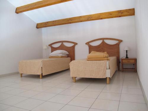 a bedroom with two beds and a chair and a table at Appartement lumineux avec VUE MER pour 6 personnes in Valras-Plage