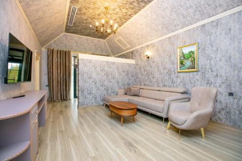a living room with a couch and a table at Nohur Hotel Gabala in Gabala