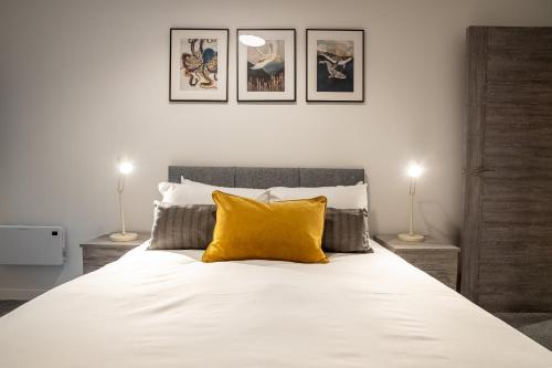 ein Schlafzimmer mit einem Bett mit gelbem Kissen darauf in der Unterkunft Bayard Apartments -Two Bedroom Apartment - Contractors Welcome in Peterborough