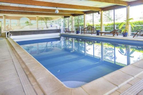 una piscina de agua azul en una casa en Eure95KM PARIS JO prés Giverny et Macarthur piscine intérieure chauffee, en Chambray