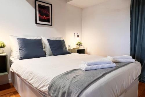 een slaapkamer met een groot wit bed met blauwe kussens bij El Mar de Casa en Cudillero by Batuecas in Cudillero