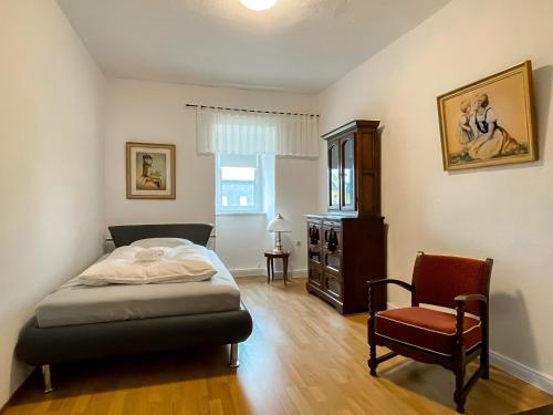 ein Schlafzimmer mit einem Bett und einem Stuhl darin in der Unterkunft Apartment Fuchsbau in Senftenberg