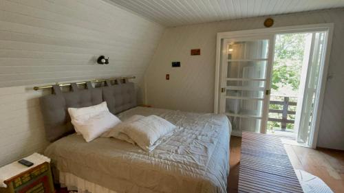 a bedroom with a bed and a large window at Pousada Casa Thede in Salvador do Sul