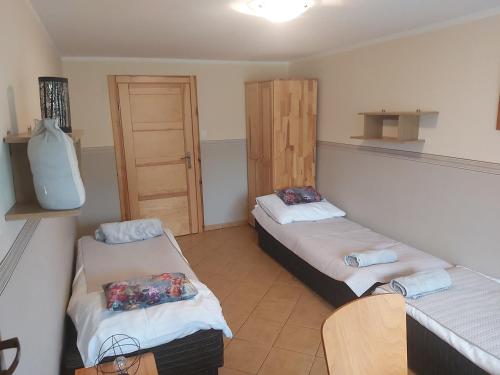 ウェバにあるPokoje gościnne Annaのベッド2台とドアが備わる小さな部屋です。