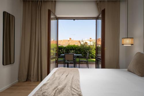 a bedroom with a bed and a balcony with a table at Upper Sea View Apartments in Vrsar