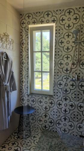 a bathroom with a window and a tile wall at DIENVIDI in Bernāti