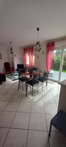 un salon avec une table et des chaises de salle à manger dans l'établissement Maison de vacances - Baie du Mont Saint Michel, à Saint-Jean-le-Thomas