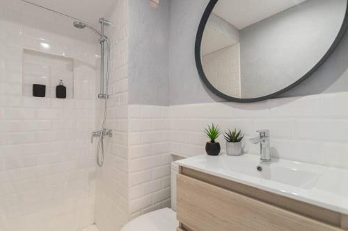 a white bathroom with a sink and a mirror at Banana Beach Boutique Studio in Platja  d'Aro