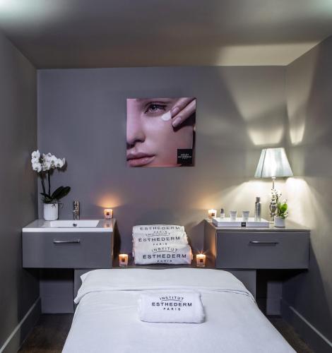 a bedroom with a bed and two sinks and a poster of a woman at Les Lodges Sainte-Victoire Hotel & Spa in Aix-en-Provence
