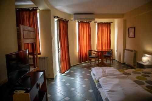 a bedroom with a bed and a table and chairs at Hotel Balevurov in Sandanski