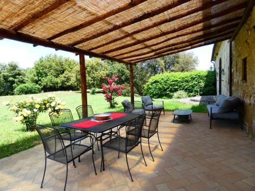 a patio with a table and chairs under a wooden pergola at SCAPPO IN UMBRIA, Casale Monti in Montoro