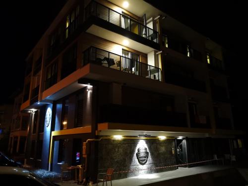 a building with a sign on the side of it at night at Deluxe Beach Residence in Samsun