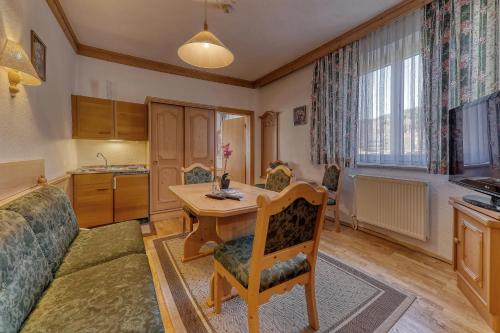 a living room with a table and a kitchen at Hotel Bayerischer Hof in Bodenmais