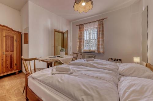 a bedroom with a large white bed and a table at Hotel Bayerischer Hof in Bodenmais