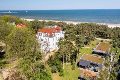 an aerial view of a large white building on the beach at Pineblue Villas in Heringsdorf