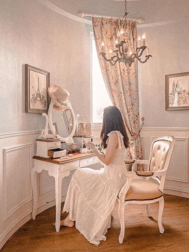 a young girl sitting at a desk with a mirror at 法國小古堡-Chateau de France in Wujie
