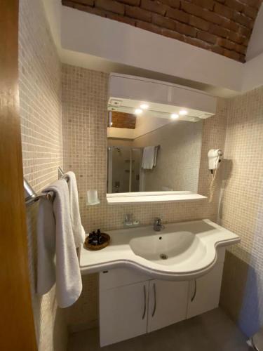 y baño con lavabo blanco y espejo. en Munahan, en Bodrum City
