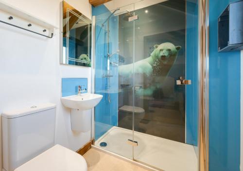 a bathroom with a bear in the shower at The Old Cowshed in Stone