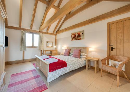 a bedroom with a bed and a chair in a room at The Old Cowshed in Stone