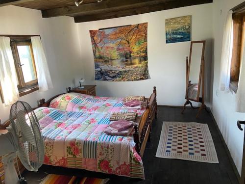 um quarto com uma cama e um quadro na parede em Lavender and Poppy cottages em Bebrovo