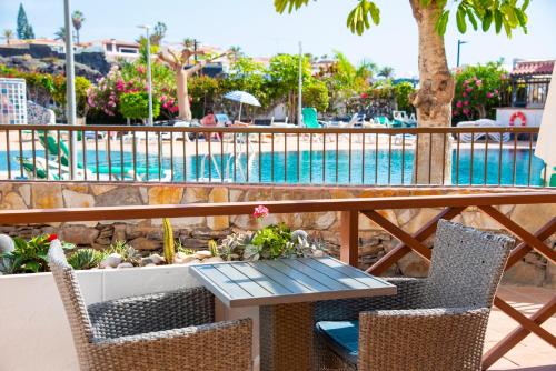 uma mesa e cadeiras ao lado de uma piscina em Neptuno Pool and beach private access em Puerto de Santiago