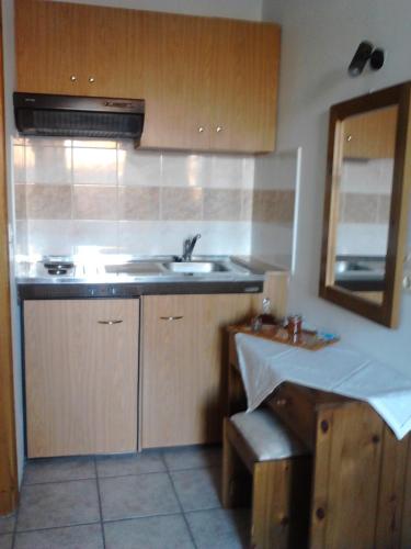 a kitchen with wooden cabinets and a sink and a mirror at Karagiannaki in Skála Sykaminéas